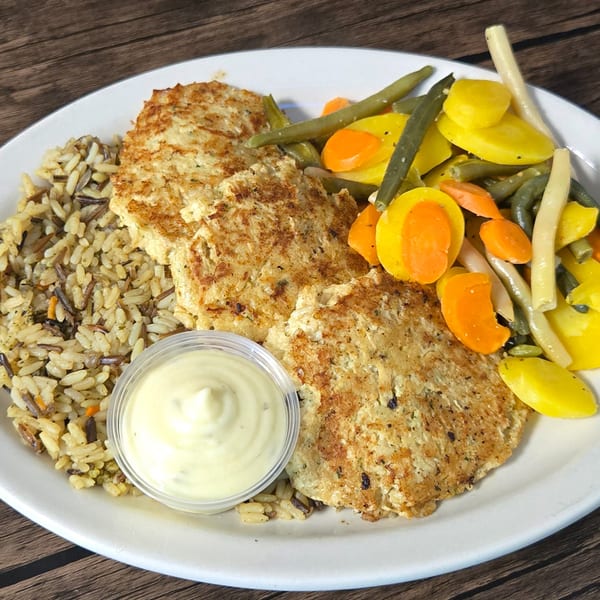 Gateway Cafe's American dish with two patties, wild rice, mixed vegetables, and a side of sauce.