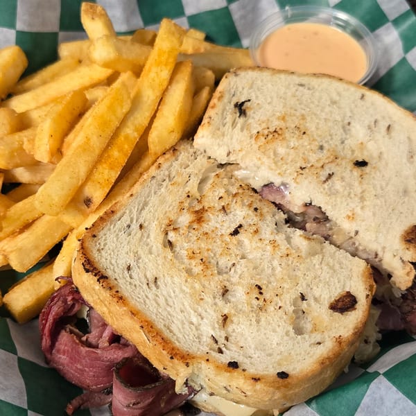 A Gateway Cafe Reuben sandwich with corned beef, Swiss cheese, sauerkraut, and Russian dressing, served with fries.